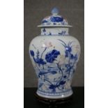 A Chinese baluster form porcelain jar and cover, blue and white, painted with flowers and storks,