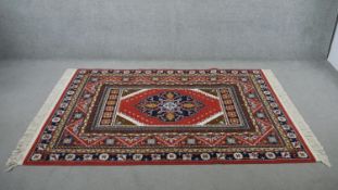 A Kashmir motif Axminster rug, on a red ground. L.205 W.136cm