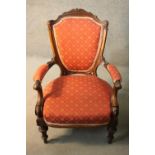 A late 19th century carved mahogany armchair in geometric floral upholstery on fluted tapering