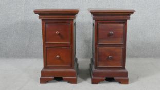 A pair of contemporary hardwood bedside chests, of two drawers with knob handles, and fielded