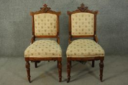 A pair of Victorian walnut Aesthetic movement side chairs, with ornate carved crest, the back and