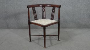 An Edwardian mahogany corner chair, with pierced splats to the back, over a cream upholstered