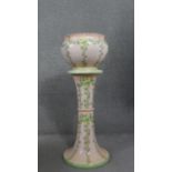 A Victorian jardiniere on stand with all over floral glazed decoration. H.85cm Dia.31cm.