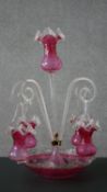 A Victorian ruby glass epergne with central stem and four scrolling branches each with hanging