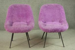 A pair of circa 1950s chairs, upholstered in shaggy purple fabric, on splayed powder coated metal