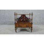 A Victorian figured walnut Canterbury, with ornately pierced dividers, over a single drawer with