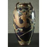 A Japanese Meiji period Satsuma pottery vase, with three handles, decorated with a dragon on a