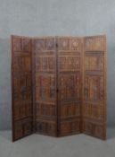 An Indian carved hardwood four fold screen, formed of many panels with carved and pierced leaves and