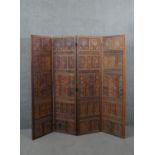 An Indian carved hardwood four fold screen, formed of many panels with carved and pierced leaves and