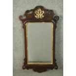 A mid 18th century mahogany and parcel gilt fretwork mirror, the crest with a carved and pierced