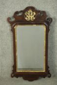 A mid 18th century mahogany and parcel gilt fretwork mirror, the crest with a carved and pierced