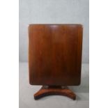 A Biedermeier style mahogany tilt top dining table, with a rectangular top, on a flame mahogany