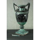 A large late 19th century majolica vase, in hues of black and green, with a pair of double