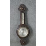 A late 19th century carved oak cased barometer with silvered dial. H.72 W.24cm