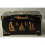 A 20th century Chinese camphorwood trunk, ebonised, carved with sailing boats in relief, with a