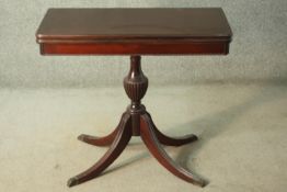 A George III style mahogany tea table, on a turned and reeded vase form stem, on a quatraform