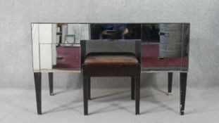 A mid 20th century mirrored kneehole dressing table, with an arrangement of five short drawers, on