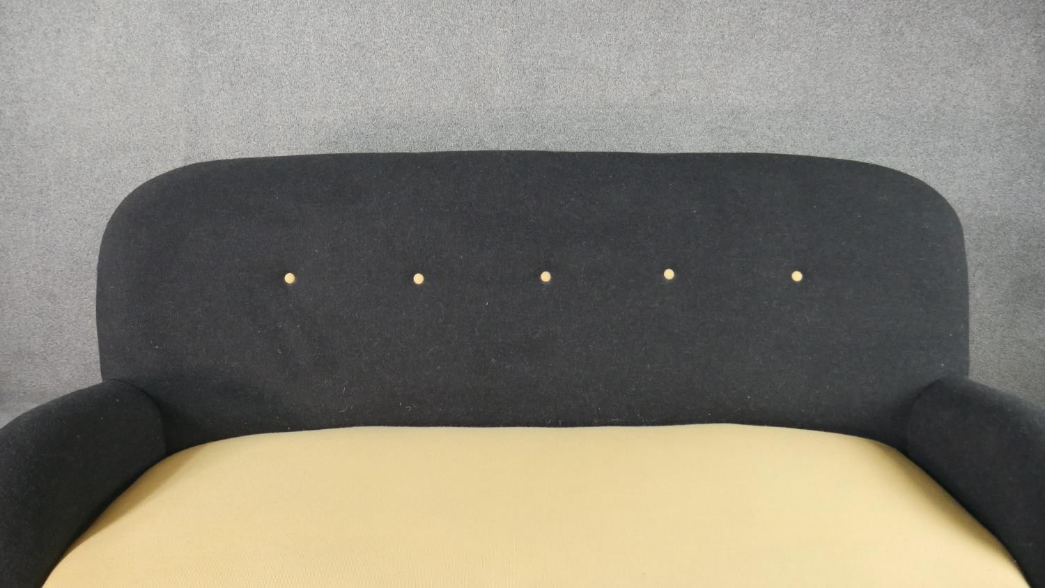 A circa 1950s two seater sofa,, the buttoned back upholstered in black fabric, over a yellow - Image 3 of 6