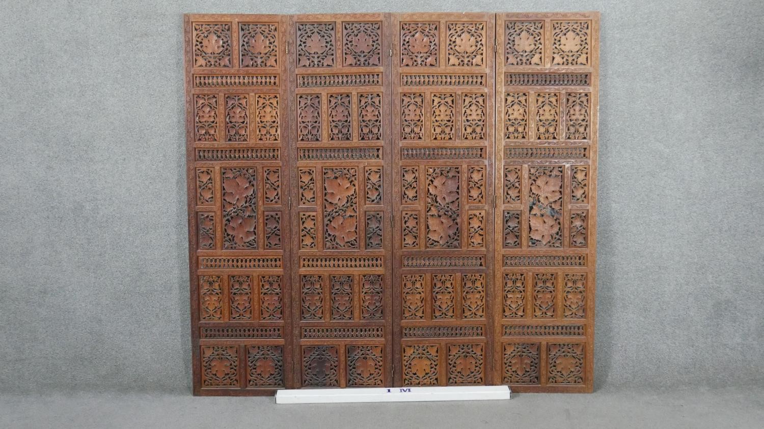 An Indian carved hardwood four fold screen, formed of many panels with carved and pierced leaves and - Image 8 of 8
