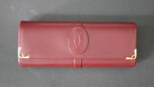A boxed leather Must de Cartier glasses travel case with suede interior and raised monogram to the