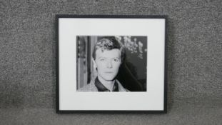 A framed black and white photograph portrait of David Bowie, with Brider & Bull label verso. H.32