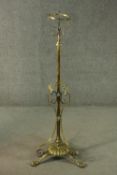 A 19th century brass extending standard stand for an oil lamp on scrolling tripod base. H.190cm (