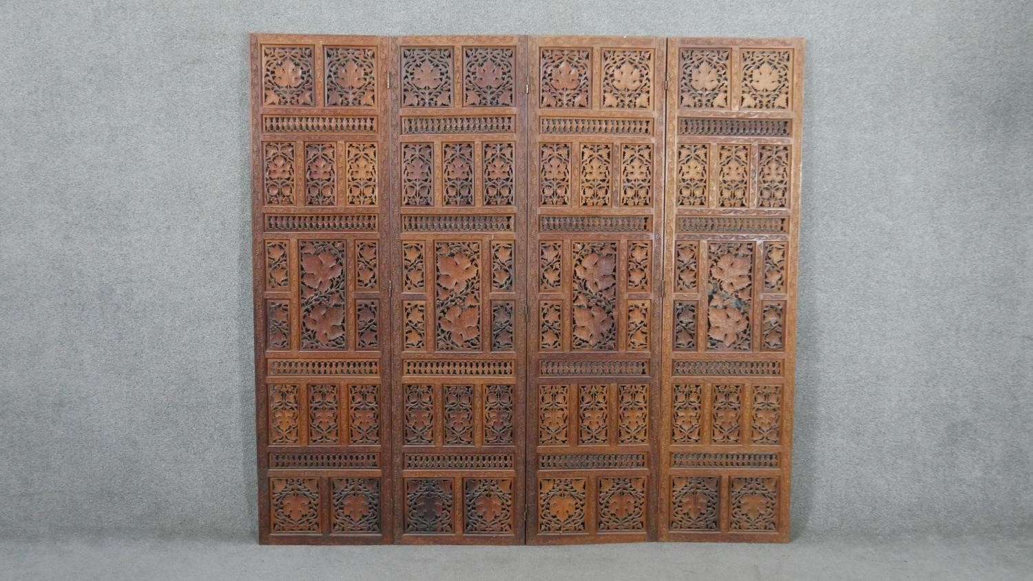 An Indian carved hardwood four fold screen, formed of many panels with carved and pierced leaves and - Image 5 of 8