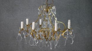 A vintage eight branch chandelier with scrolling gilt metal frame and cut crystal drops. H.47 W.60cm