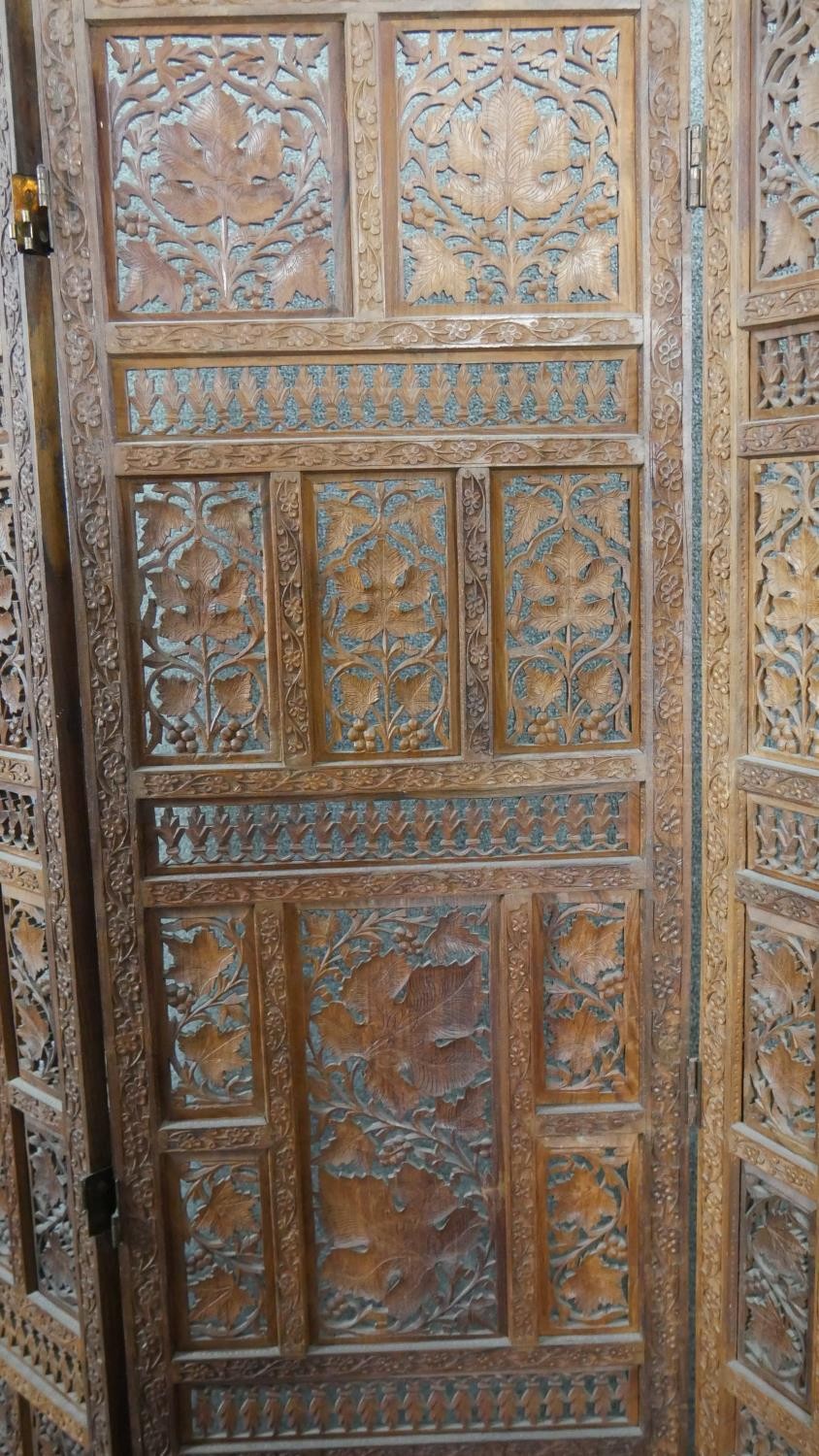 An Indian carved hardwood four fold screen, formed of many panels with carved and pierced leaves and - Image 2 of 8