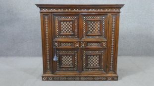 An Anglo-Indian Vizagapatam bone inlaid hardwood cabinet, with two panelled doors, enclosing a