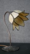 A Tiffany style stained glass desk lamp, the shade of flowerhead form, on a curved stem with a