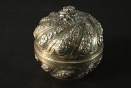An Indian repoussé floral design dried fruit box with floral form finial, gilded interior and spiral