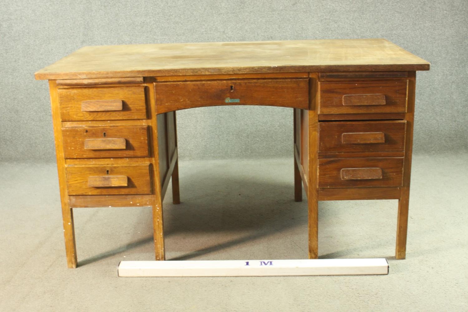 A circa 1940s oak desk, the rectangular top over two slides, and an arrangement of seven drawers - Image 2 of 8