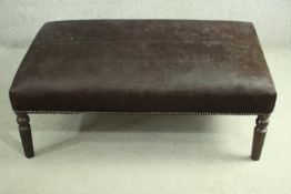 A contemporary cow hide stool, of rectangular form with a studded edge, on turned legs. H.38 W.111
