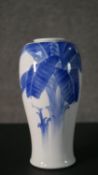 A Japanese blue and white ovoid form porcelain vase hand painted with banana tress and character