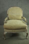 A Louis XV style limed oak fauteuil armchair, with a rounded back, upholstered to the back, arms and