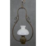 A Colonial brass hanging lamp, the frame of pear form, with a milk glass shade. H.74 W.40cm