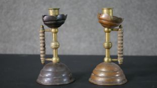 Two Benham & Froud Christopher Dresser candlesticks, brass and copper with turned wood handles. H.17