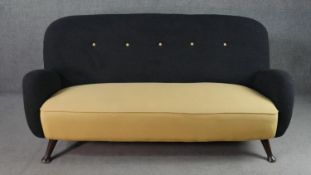 A circa 1950s two seater sofa,, the buttoned back upholstered in black fabric, over a yellow
