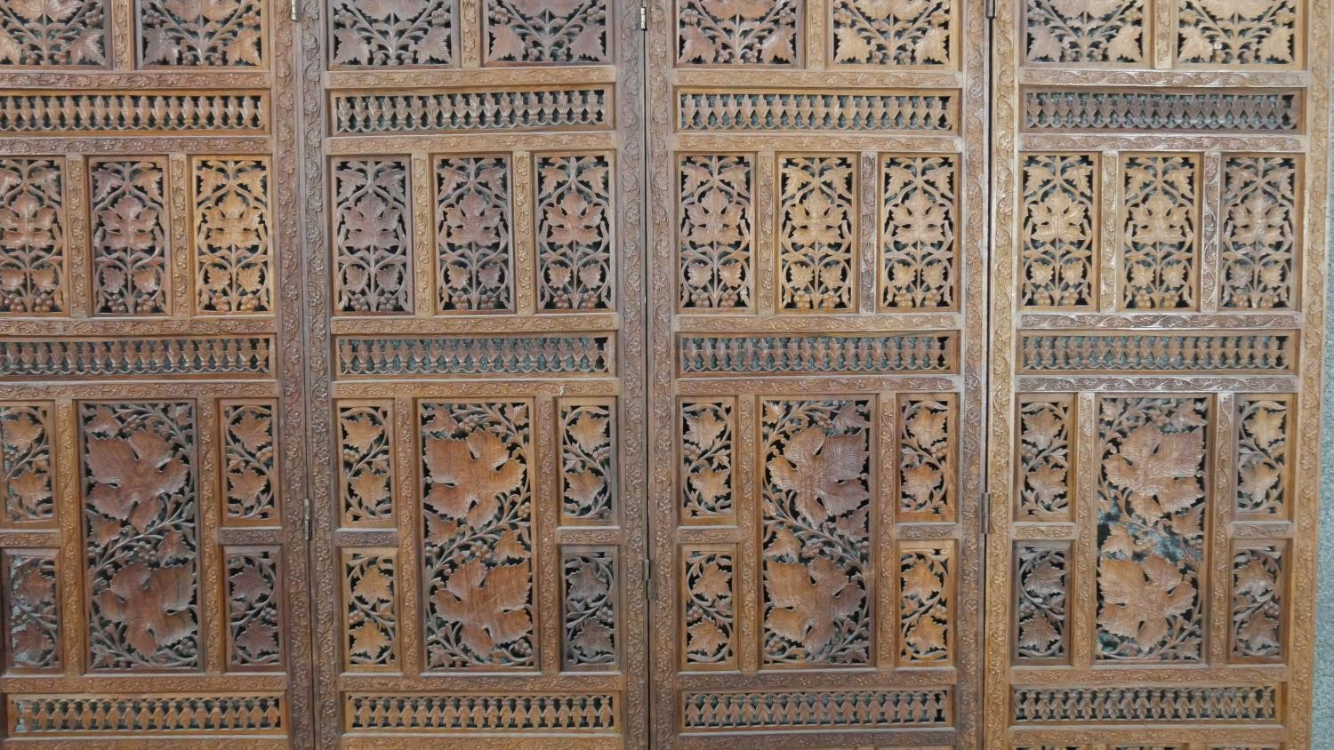 An Indian carved hardwood four fold screen, formed of many panels with carved and pierced leaves and - Image 7 of 8