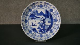 A Kangxi period Chinese blue and white plate with a archer on horse back hunting and lotus design
