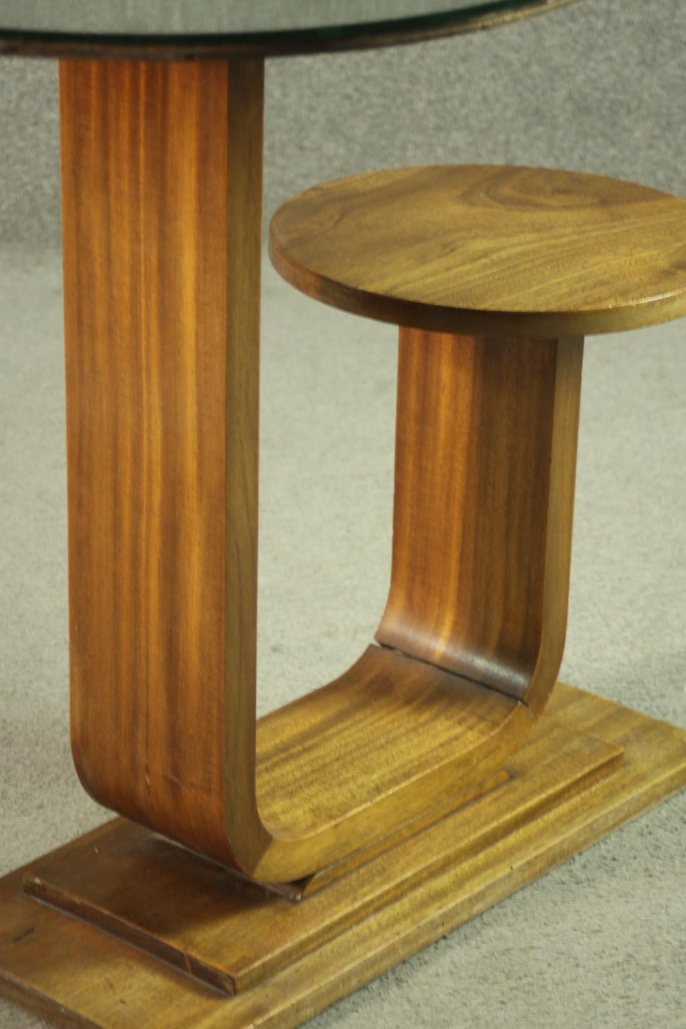 An Art Deco teak table and stool, with a circular glass table top, on a support which curves up to a - Image 5 of 8