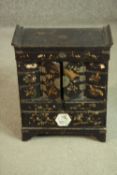 A Japanese Meiji period black lacquered tabletop cabinet, with a rising lid over two cupboard doors,