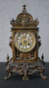 A 19th century bronze pierced foliate design mantle clock with gilt face and classical motifs, white