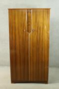 A circa 1950’s Uniflex figured walnut wardrobe the two doors opening to reveal hanging space, a