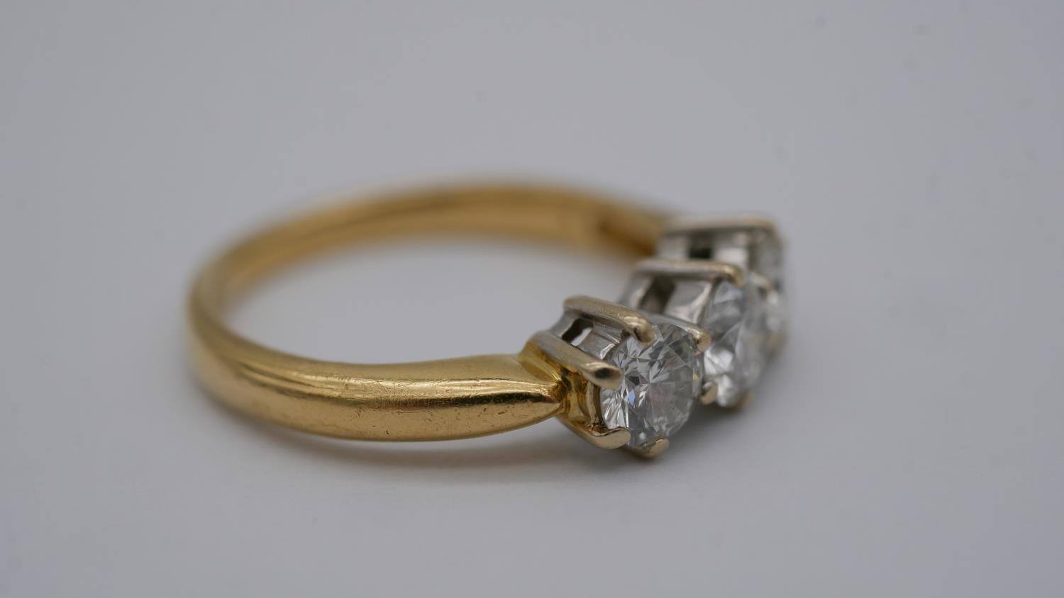 A 18 carat yellow gold and platinum three stone diamond ring, set with three round old cut