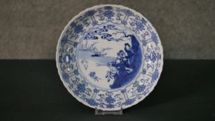 A Kangxi period Chinese blue and white plate with a hunting scene and lotus design border,