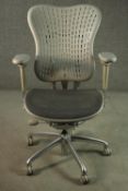 A Formway style office chair, in grey, with a pierced back, and adjustable arms, on a five point