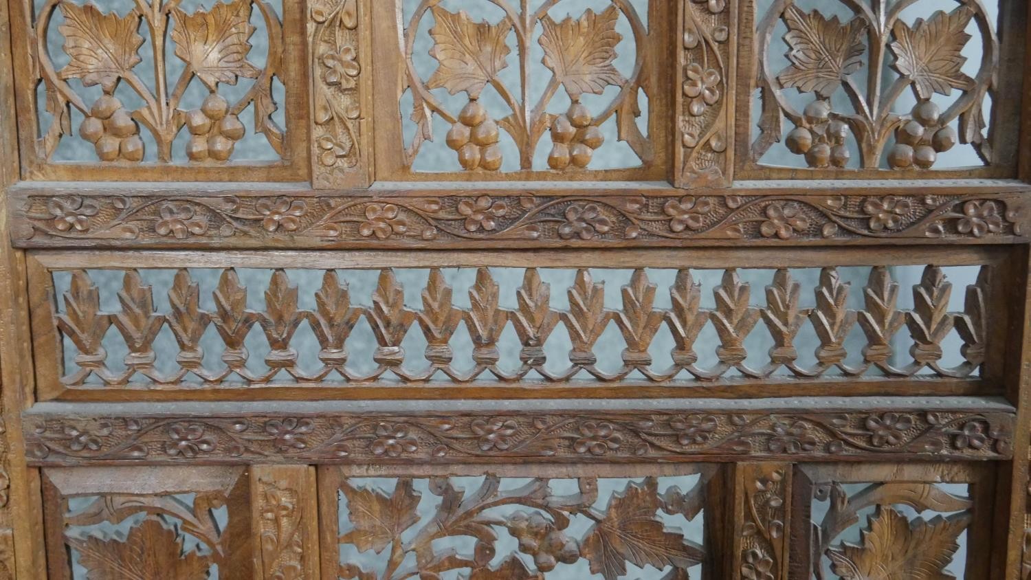 An Indian carved hardwood four fold screen, formed of many panels with carved and pierced leaves and - Image 4 of 8