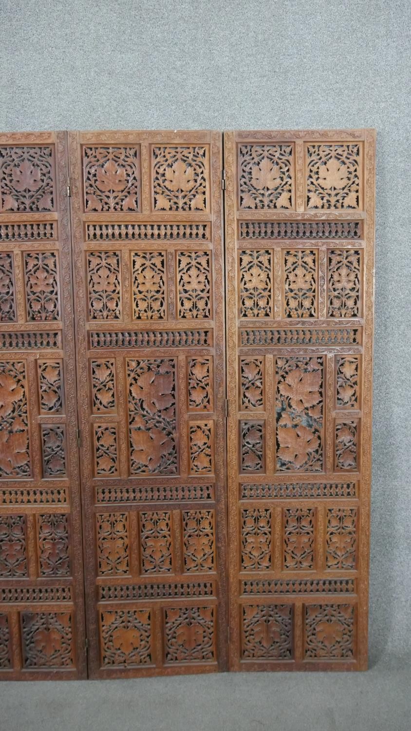 An Indian carved hardwood four fold screen, formed of many panels with carved and pierced leaves and - Image 6 of 8